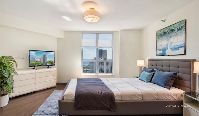bedroom featuring wood finished floors and baseboards