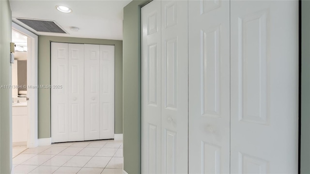 interior space with a closet, light tile patterned floors, baseboards, and visible vents