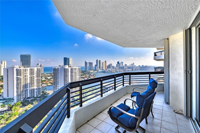 balcony with a water view and a view of city