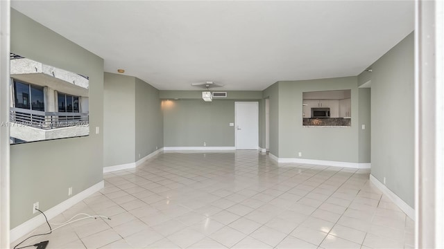unfurnished living room with light tile patterned floors, visible vents, and baseboards
