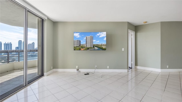 unfurnished room featuring light tile patterned floors, baseboards, and plenty of natural light