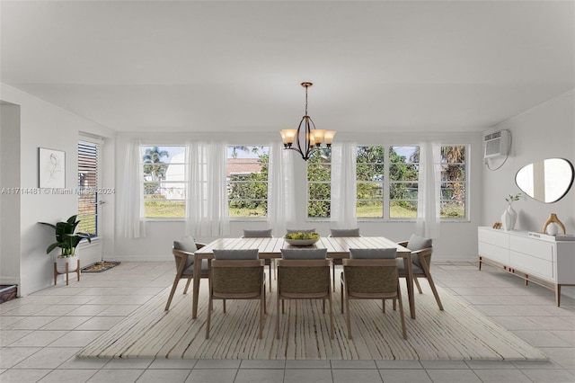 dining space with light tile patterned floors, a wall unit AC, and an inviting chandelier