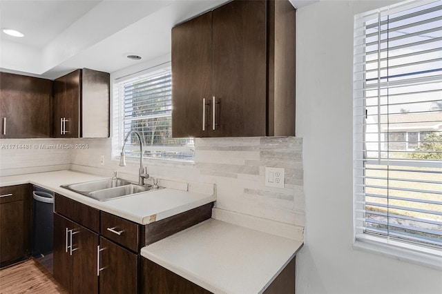 kitchen with dark brown cabinets, sink, and tasteful backsplash