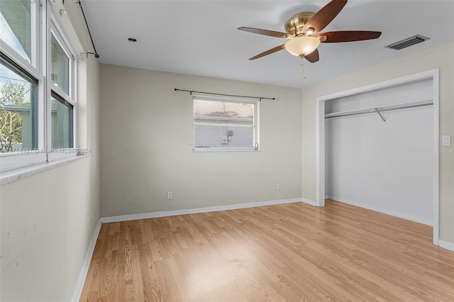 unfurnished bedroom with a closet, light hardwood / wood-style floors, and ceiling fan