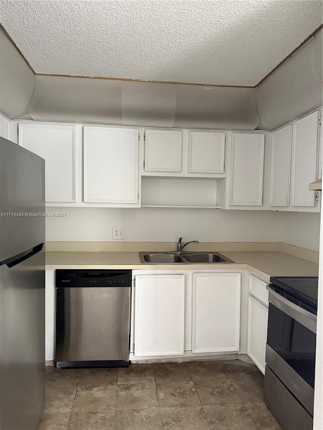 kitchen with white cabinetry, sink, stainless steel appliances, and a textured ceiling