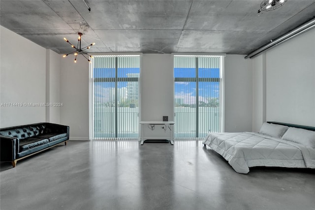 bedroom with a notable chandelier, expansive windows, access to outside, and concrete floors