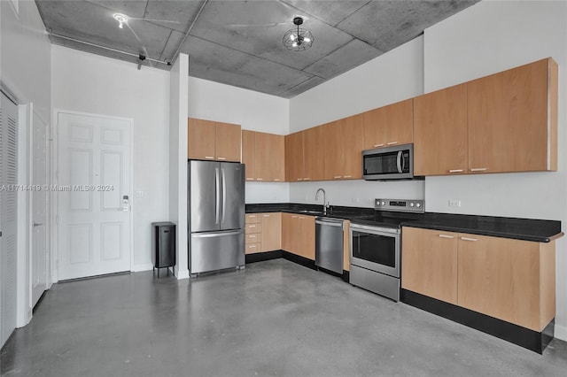 kitchen with sink, a high ceiling, and appliances with stainless steel finishes