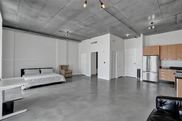 bedroom featuring a towering ceiling and stainless steel refrigerator