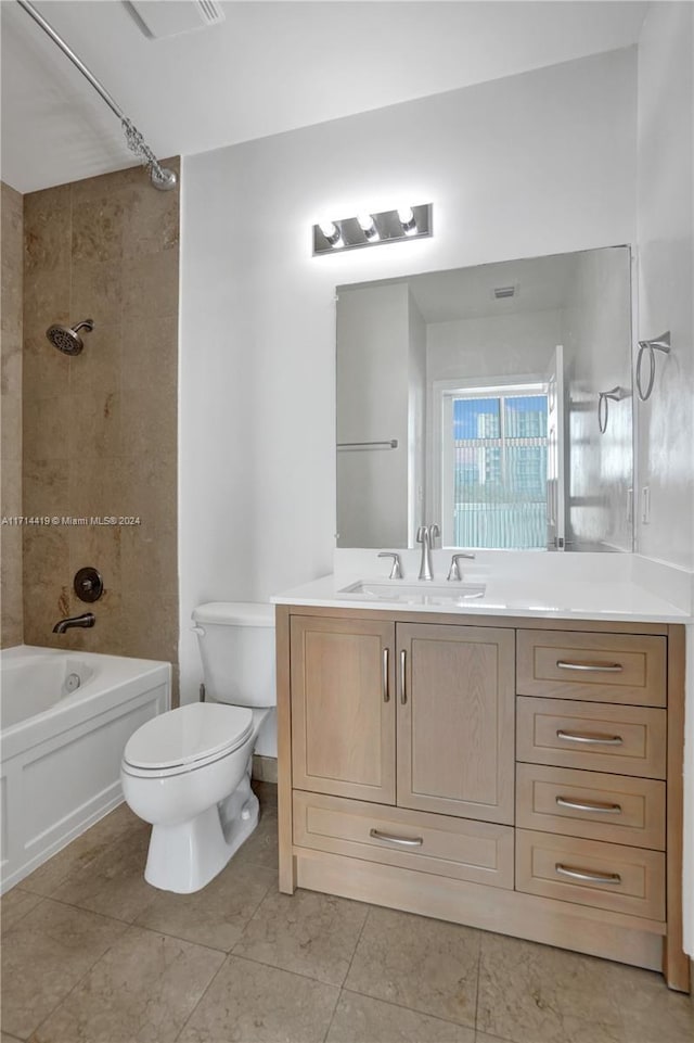 full bathroom with tile patterned floors, vanity, tiled shower / bath combo, and toilet