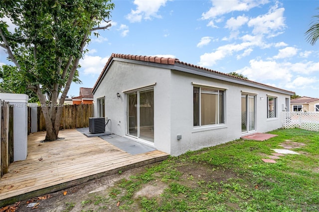 back of house with central AC, a yard, and a wooden deck