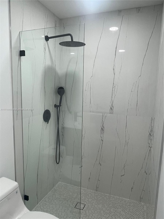 bathroom with tiled shower and toilet