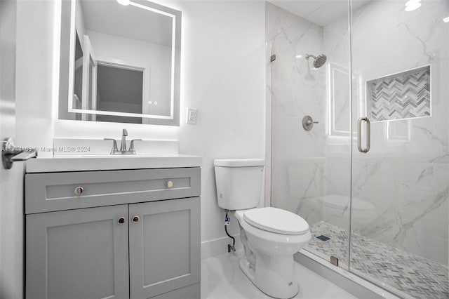 bathroom featuring vanity, toilet, and a shower with shower door