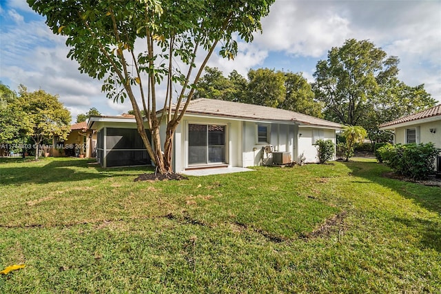 rear view of house featuring central AC and a yard