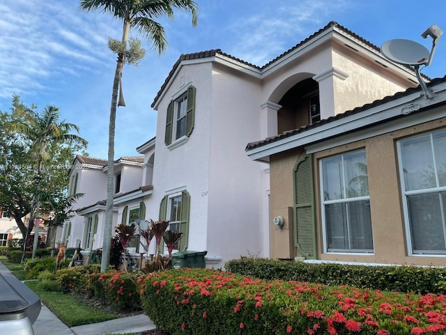 view of home's exterior featuring a tile roof and stucco siding