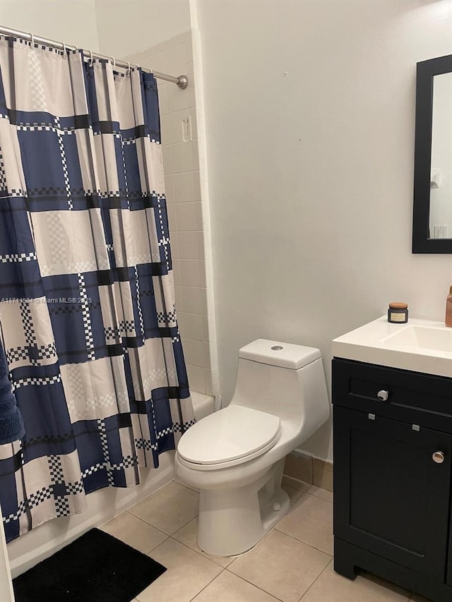 bathroom featuring tile patterned flooring, toilet, vanity, and shower / bath combo with shower curtain