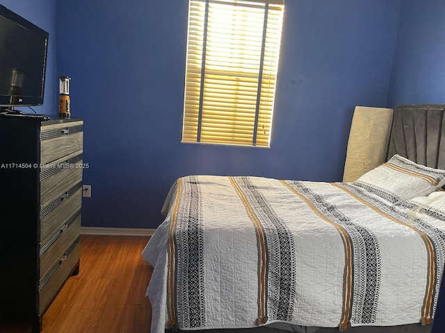 bedroom with wood finished floors and baseboards