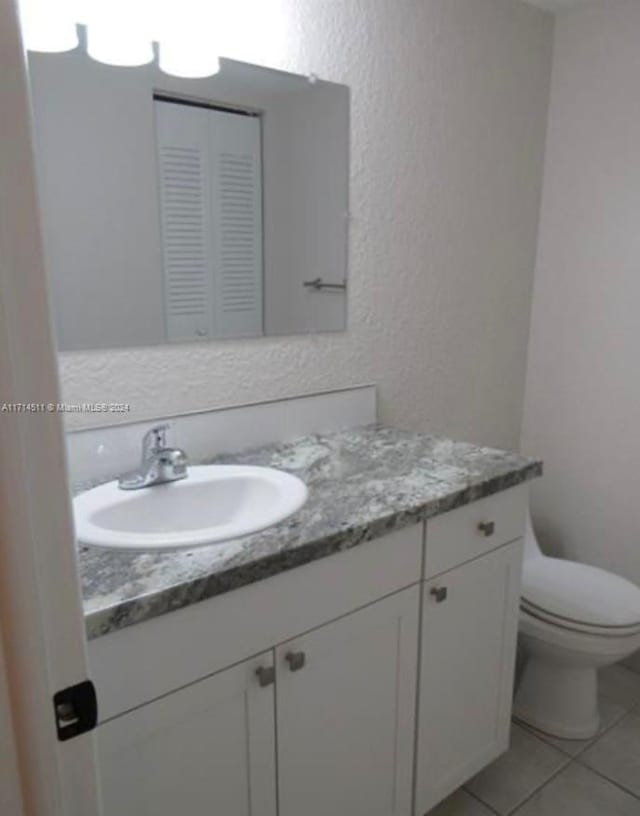 bathroom featuring tile patterned floors, vanity, and toilet