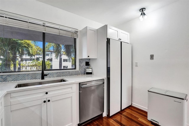 kitchen with white cabinetry, sink, dark wood-type flooring, stainless steel dishwasher, and white fridge