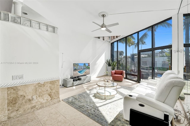 living room featuring light tile patterned floors, a wall of windows, and ceiling fan