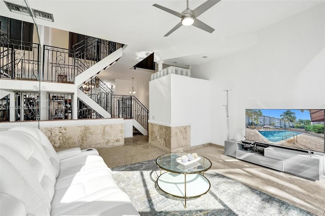 living room with ceiling fan and a towering ceiling