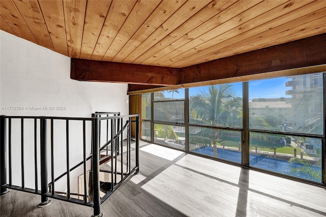 unfurnished sunroom with beamed ceiling and wooden ceiling