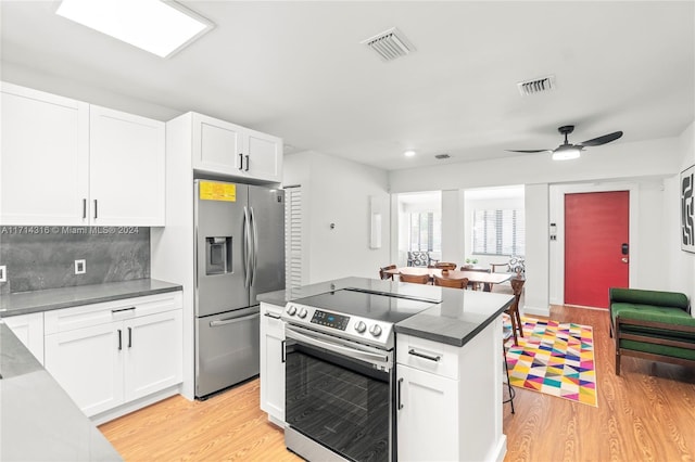 kitchen featuring white cabinets, stainless steel appliances, and light hardwood / wood-style flooring