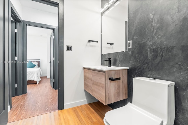 bathroom featuring vanity, wood-type flooring, and toilet