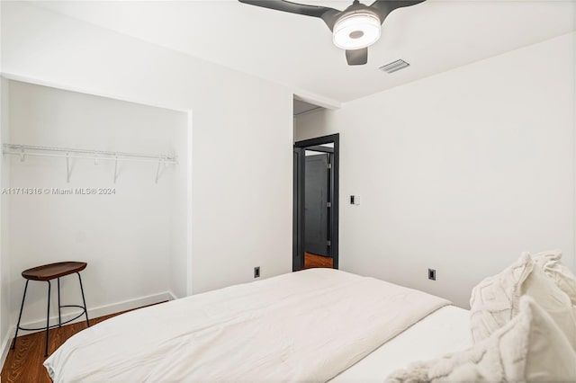 bedroom with ceiling fan, dark hardwood / wood-style flooring, and a closet