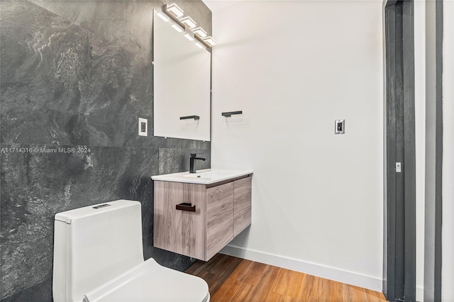 bathroom featuring hardwood / wood-style floors, vanity, tile walls, and toilet