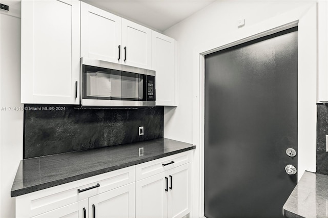 kitchen featuring decorative backsplash and white cabinets