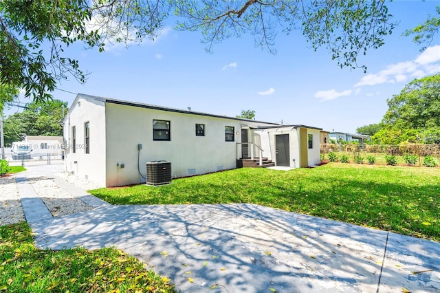 back of house with a yard and cooling unit