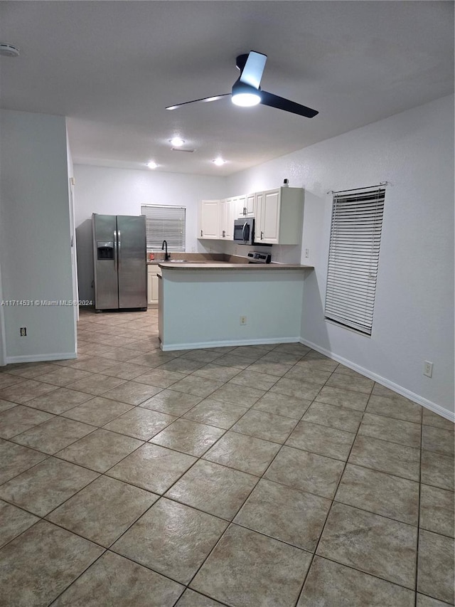 kitchen featuring ceiling fan, sink, kitchen peninsula, white cabinets, and appliances with stainless steel finishes