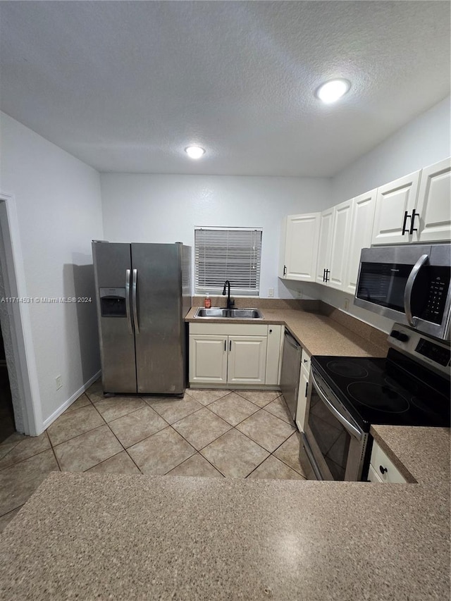 kitchen featuring a textured ceiling, sink, white cabinetry, and stainless steel appliances