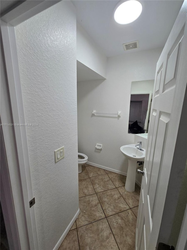 bathroom featuring sink, tile patterned flooring, and toilet