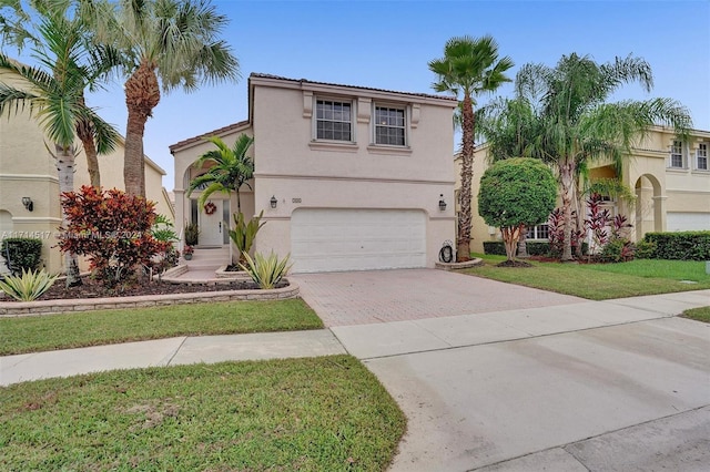 mediterranean / spanish-style home with a garage and a front lawn