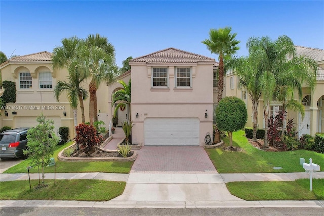 mediterranean / spanish-style home featuring a garage and a front lawn