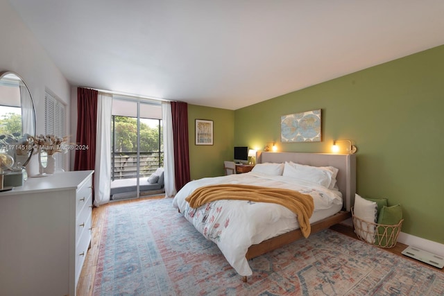 bedroom with access to exterior and light wood-type flooring