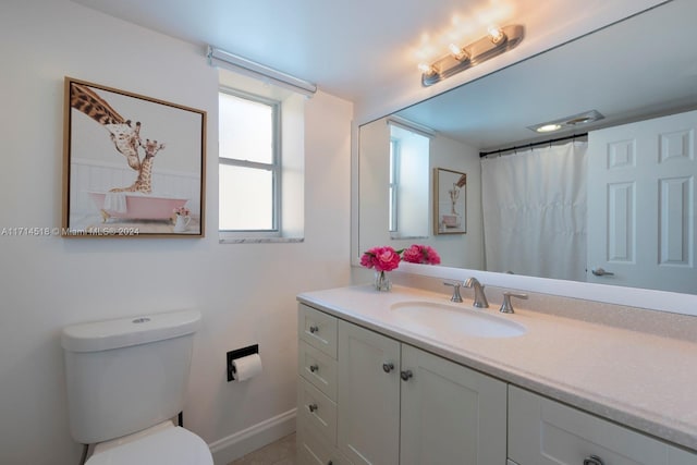 bathroom with vanity, curtained shower, and toilet