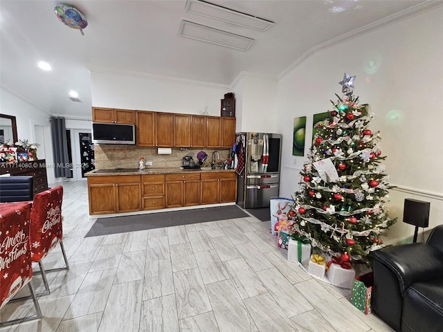 kitchen featuring sink, decorative backsplash, stainless steel fridge, ornamental molding, and black electric cooktop