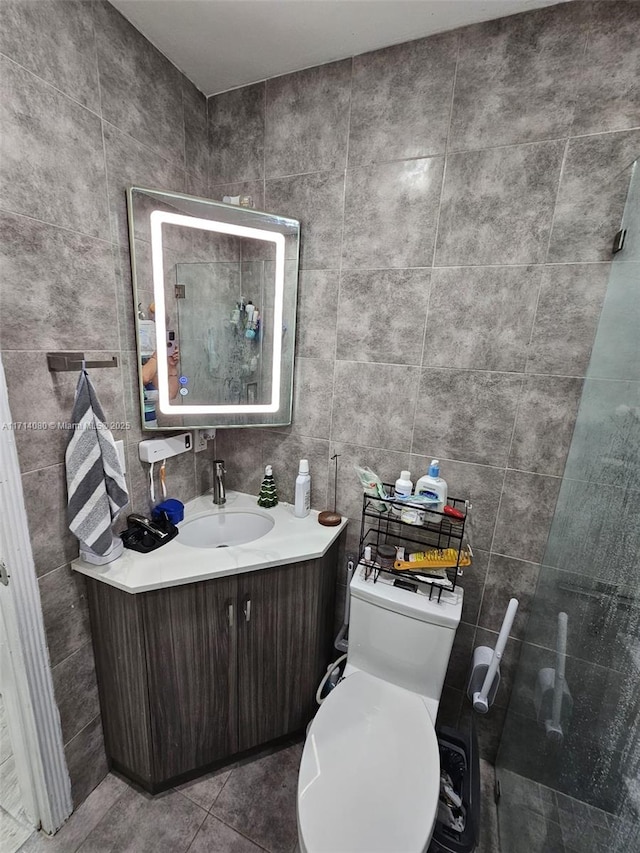 bathroom with tile patterned flooring, vanity, tile walls, and toilet