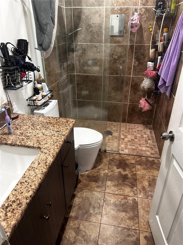 bathroom with vanity, a shower with shower door, and toilet