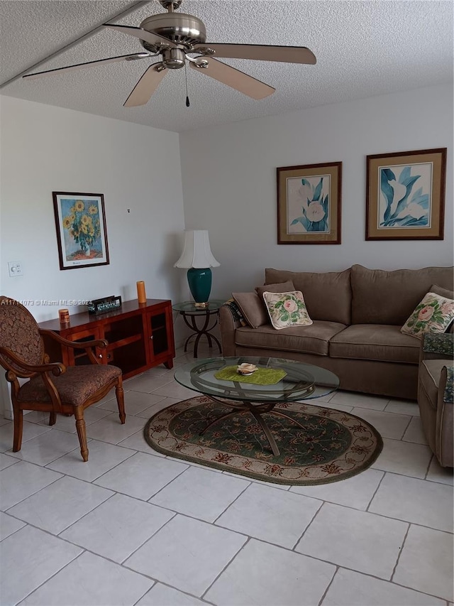 tiled living room featuring ceiling fan and a textured ceiling