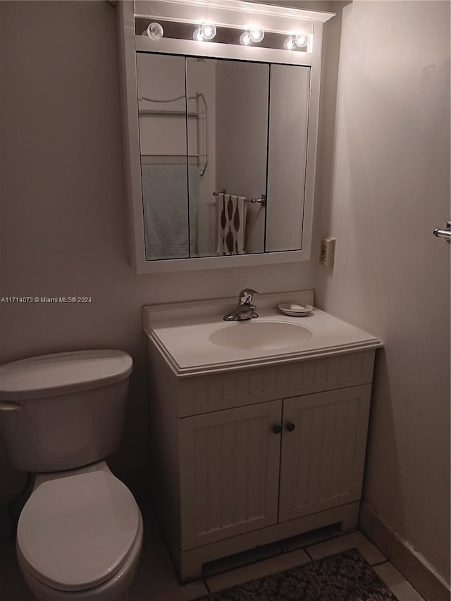 bathroom featuring tile patterned flooring, vanity, and toilet