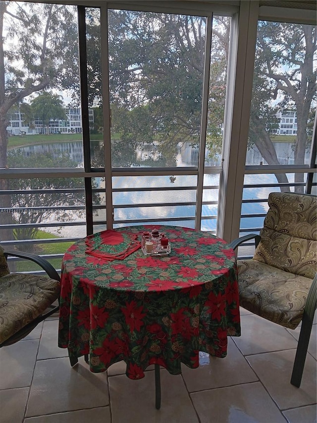 sunroom featuring a water view