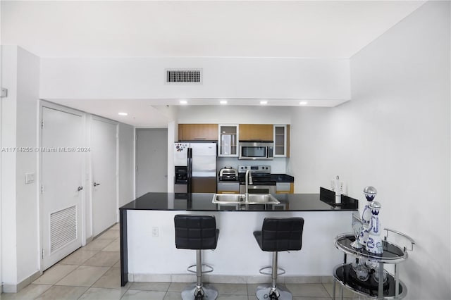 1750 N Bayshore Dr Unit 3210, Miami, FL 33132 - kitchen featuring appliances with stainless steel finishes, a peninsula, a breakfast bar area, dark countertops, and glass insert cabinets