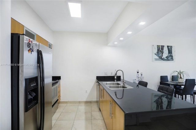 kitchen featuring appliances with stainless steel finishes, light tile patterned floors, and sink