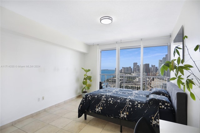 bedroom featuring a water view and light tile patterned floors