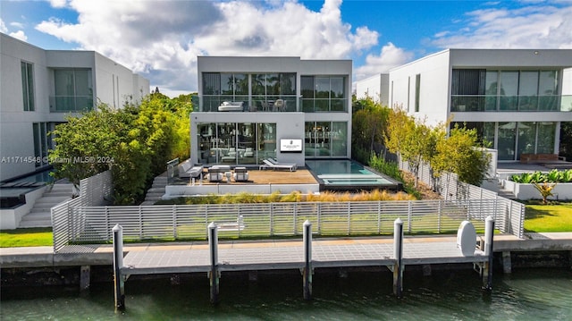 rear view of house with an outdoor living space and a water view