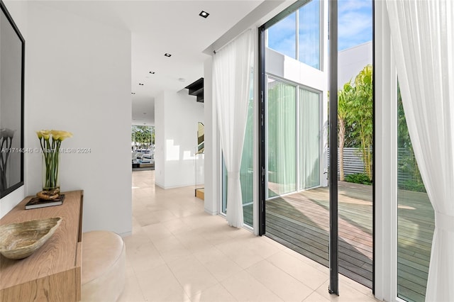 hall featuring light tile patterned floors and a wealth of natural light