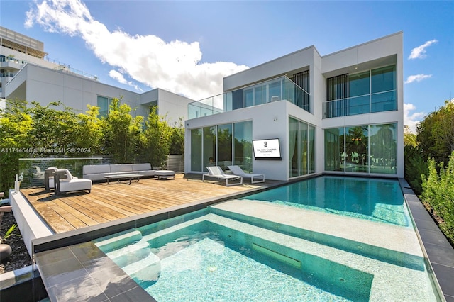 rear view of property featuring a pool side deck